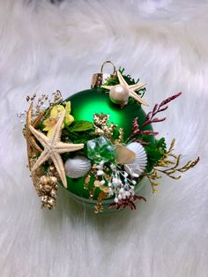 a green christmas ornament with shells and starfish