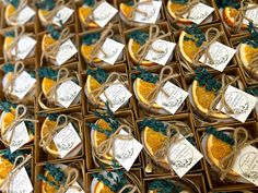 orange slices are arranged in small boxes with twine and tags tied to the sides