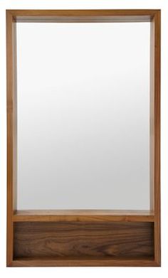 a wooden framed mirror on a white wall with a brown frame and wood trim around the edges