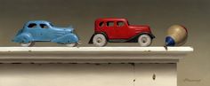 three toy cars sitting on top of a mantle