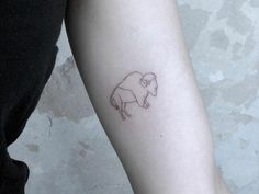 a small sheep tattoo on the arm