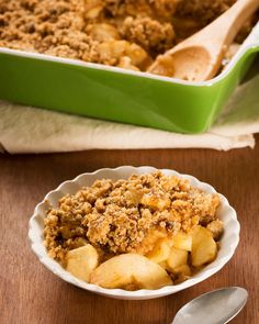 a close up of a bowl of food on a table next to a fork and spoon