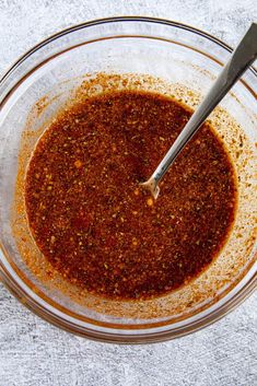 a glass bowl filled with sauce on top of a table