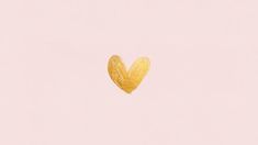 a gold heart shaped object on a light pink background with the word love written in it