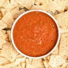 a white bowl filled with salsa surrounded by tortilla chips