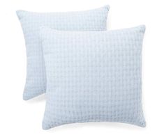 two light blue pillows sitting next to each other