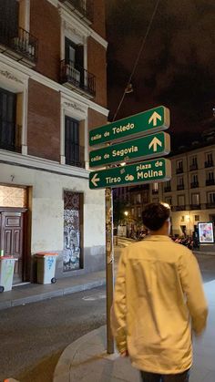 a man is walking down the street at night