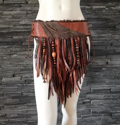 "Loincloth made out of brown and cognac genuine leathers. Detailed with braids and wooden beads. Lace ups both sides to get in and to adjust the size. Size: High hip (waistband/belt level): 32-36\" (81-91cm) Length at middle: 18\" (46 cm) See the last image for the measurements. Leathers used in this one are recycled, so no any animals were harmed to make this particular piece. This is an one of a kind item, the skirt you receive is the same one as above. Handmade from scratch by me, the designe Female Na'vi, Apocalyptic Wasteland, Nomad Fashion, Lion King Costume, Viking Warrior Woman, Pagan Fashion, Dream Warriors, How To Make Leather, Warrior Outfit