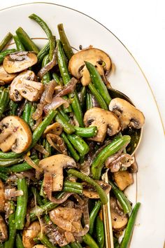 a white plate topped with green beans and mushrooms