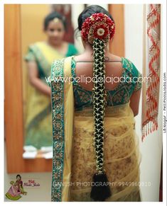 a woman wearing a yellow and green sari with a red flower in her hair