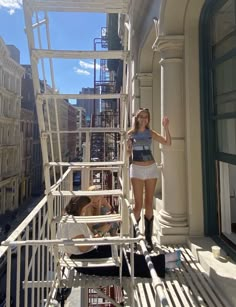 a woman standing on top of a set of stairs in front of a tall building