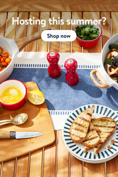 a table topped with plates and bowls filled with food next to utensils on top of a cutting board