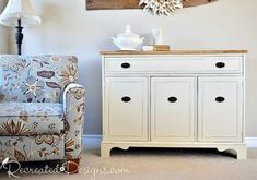 a white dresser sitting next to a blue chair