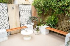 two wooden benches sitting next to each other on a patio