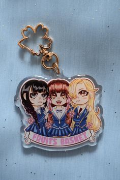 two anime characters are hanging from a keychain on a blue background with hearts