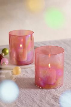 two pink candles sitting on top of a table