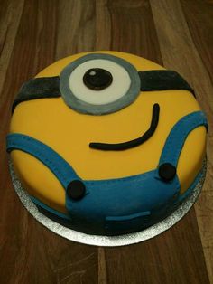 a yellow and blue cake sitting on top of a wooden table