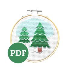 a cross stitch christmas tree in the snow with a green circle around it that says pdf