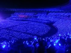 a large stadium filled with lots of people sitting on the side of it at night