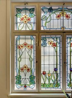 four stained glass windows with flowers on them