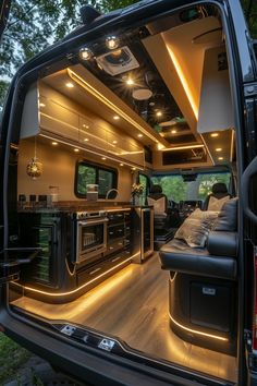 the interior of an rv with its lights on and couch in the rear door area