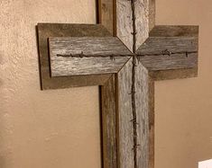 a wooden cross hanging on the side of a wall