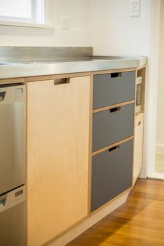 an empty kitchen with stainless steel appliances and wooden cabinets