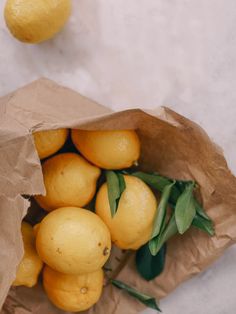 a paper bag filled with lemons on top of a table