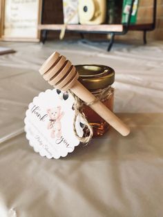 a jar of honey and a wooden stick on a table