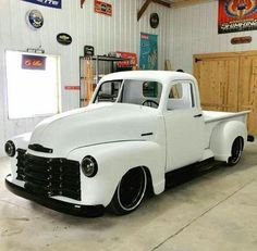 an old white truck parked in a garage