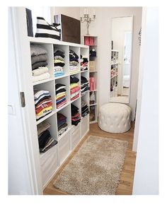 a walk in closet with lots of clothes on the shelves and carpeted flooring