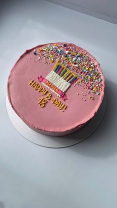 a birthday cake with pink frosting and sprinkles