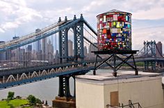 a very tall tower sitting next to a bridge with a colorful building on it's side