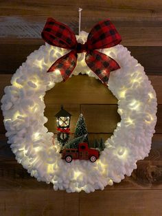 a christmas wreath with lights and a red truck