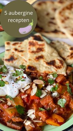 a green plate topped with food next to pita bread