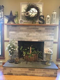 a brick fireplace with potted plants and wreaths on the mantel above it