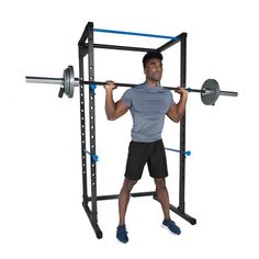 a man standing in front of a squat machine with one arm on the barbell