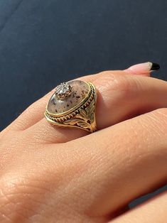 a close up of a person's hand with a ring on it