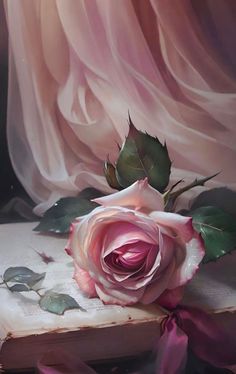 a painting of a pink rose on top of an old book with ribbon around it