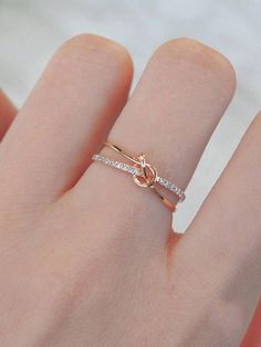 a person's hand with a gold ring on it and two diamonds in the middle