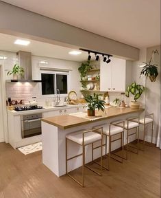 a kitchen with white cabinets and wooden counter tops next to a stove top oven in a living room