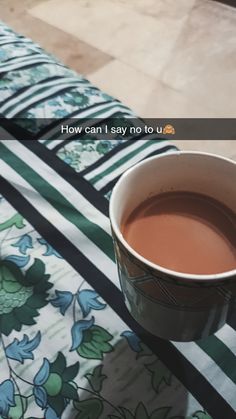 a cup of tea sitting on top of a bed