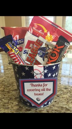 a bucket filled with candy and snacks on top of a counter