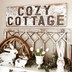 a white shelf topped with vases filled with flowers next to a sign that says cozy cottage