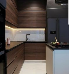 a modern kitchen with dark wood cabinets and white flooring