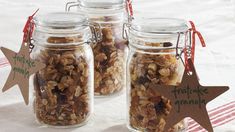 three jars filled with granola sitting on top of a table