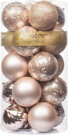 gold and silver christmas ornaments in a clear box on a white background with a golden ribbon