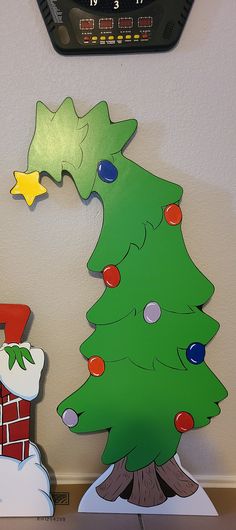 a clock mounted to the side of a wall next to a christmas tree