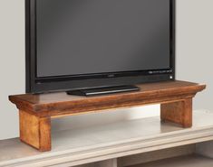 a flat screen tv sitting on top of a wooden stand in front of a white wall