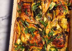 a casserole dish with chicken, vegetables and herbs in it on a marble countertop